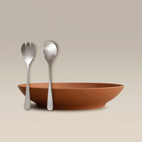 All Is Served Set orange shallow bowl with a silver fork and spoon resting against it.