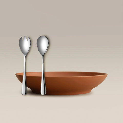 All Is Served Set orange shallow bowl with two silver utensils a fork and spoon standing beside it.