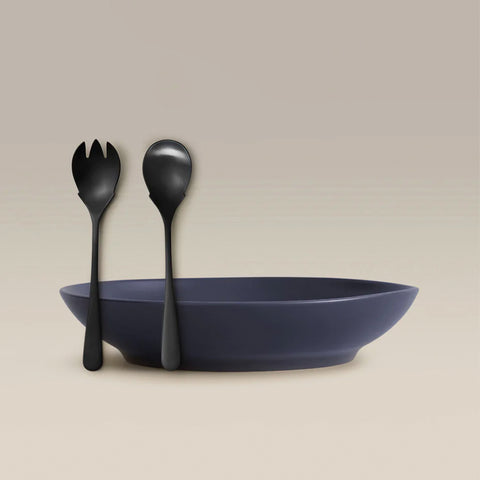 All Is Served Set two black utensils resting on the rim of a navy bowl