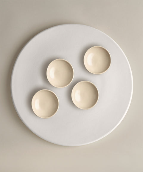 Five beige ceramic bowls arranged on a large white round platter from The Party Starter Set