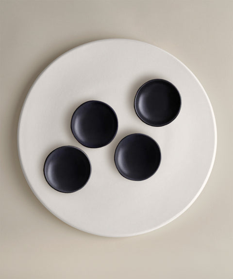 Four black bowls on a large white plate from The Party Starter Set.