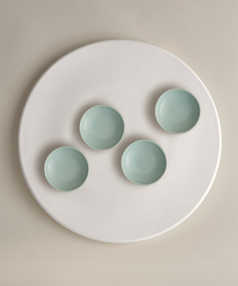 Four pale turquoise bowls arranged on a white plate from The Party Starter Set.