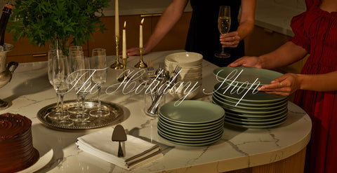 Dining table set for a holiday meal with plates, cutlery, and a cake, featuring 'The Holiday Shop' text.